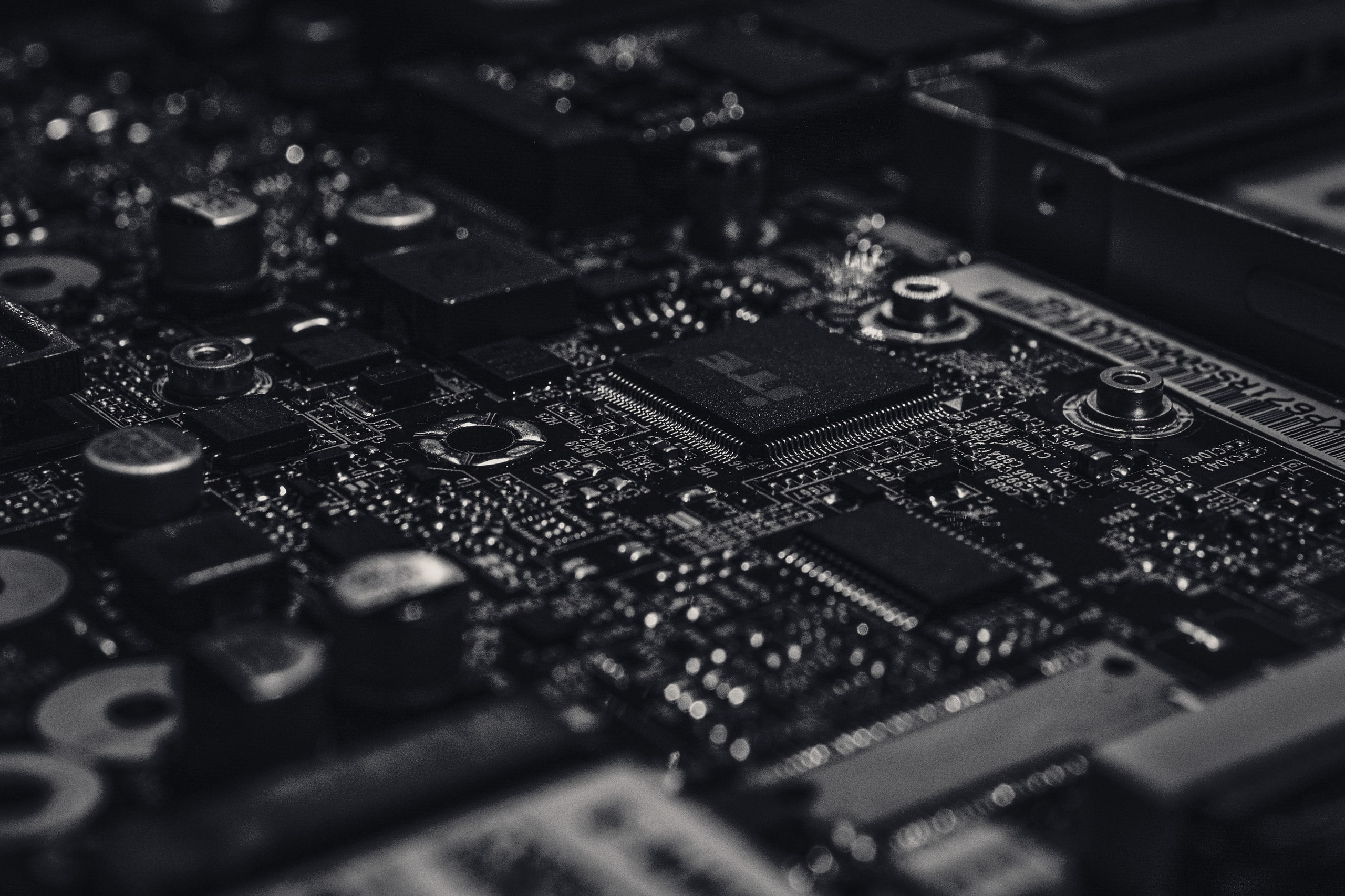 Close-up of a dark circuit board with fine traces and processors