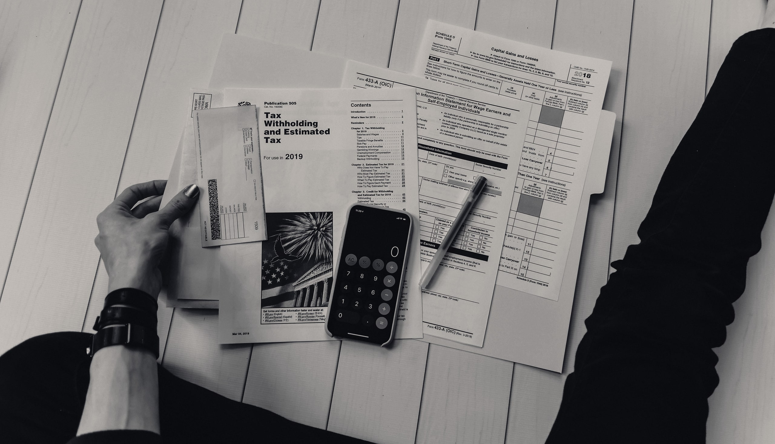 Hands working through financial documents with a calculator