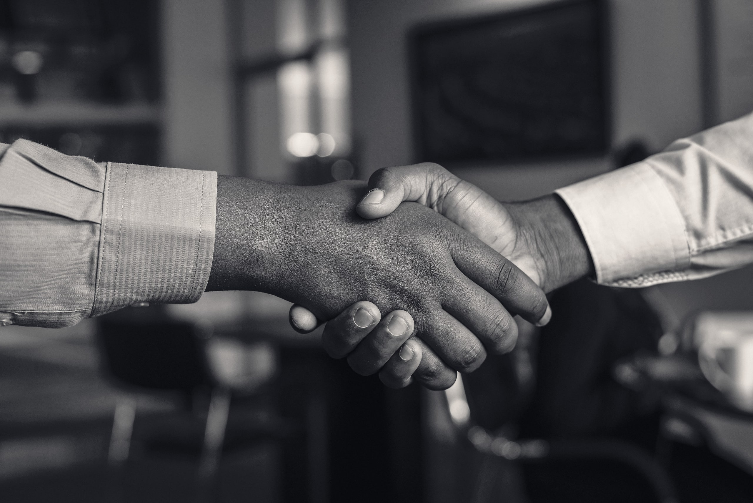 Two people shaking hands to close a deal
