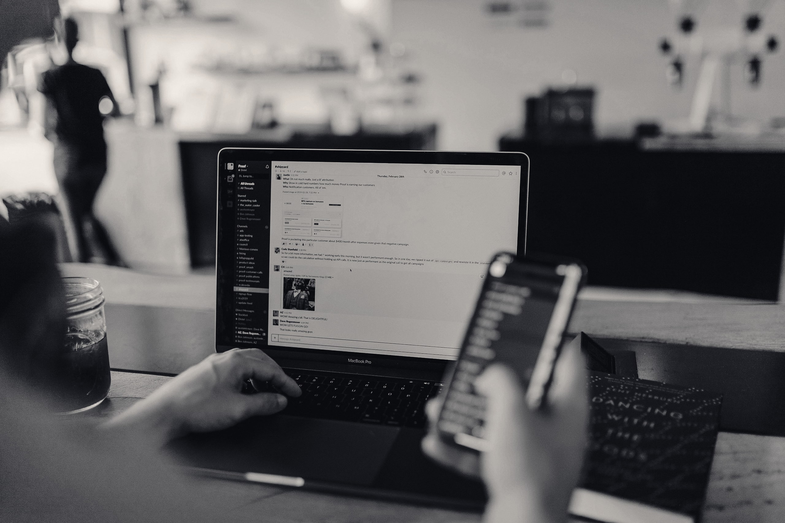 Person using a laptop and phone with a chat conversation open
